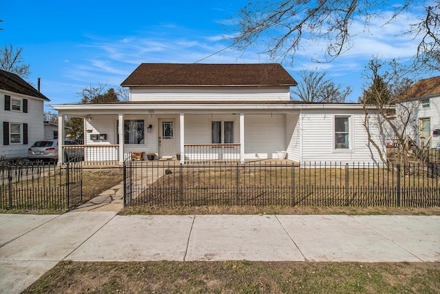 view of front of property with a porch, a fenced front yard, and roof with shingles