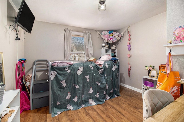 bedroom with baseboards and wood finished floors