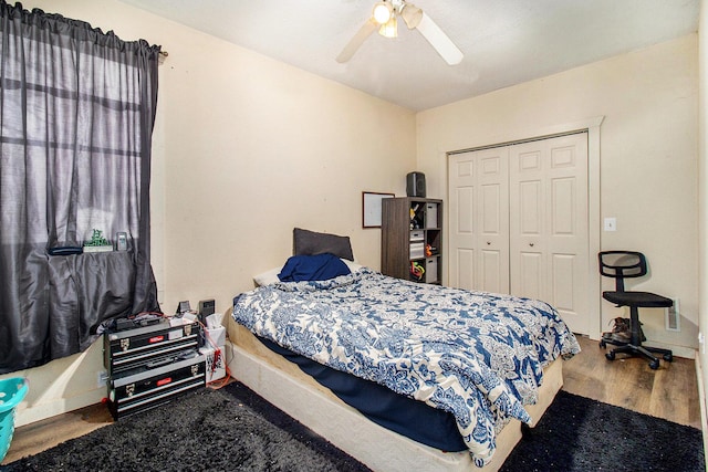 bedroom with a ceiling fan, wood finished floors, and a closet