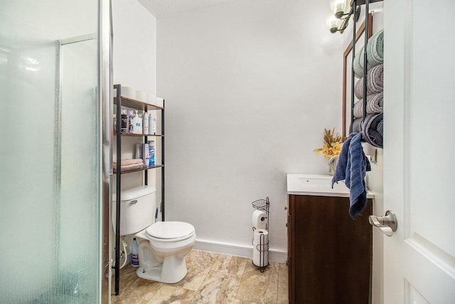 bathroom featuring baseboards, toilet, and vanity