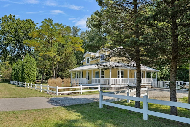 country-style home featuring a fenced front yard, a porch, and a front lawn