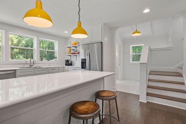 kitchen featuring dark wood-style floors, plenty of natural light, stainless steel appliances, and a sink