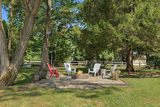 view of yard featuring an outdoor fire pit and fence