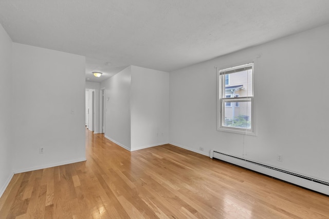 603 Gott St, Ann Arbor, MI 48103 - empty room featuring baseboard heating, light wood-type flooring, and baseboards