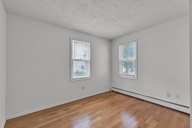 603 Gott St, Ann Arbor, MI 48103 - spare room with a baseboard radiator, light wood-style floors, a textured ceiling, and baseboards