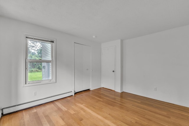 603 Gott St, Ann Arbor, MI 48103 - unfurnished bedroom with a baseboard radiator and light wood-style floors