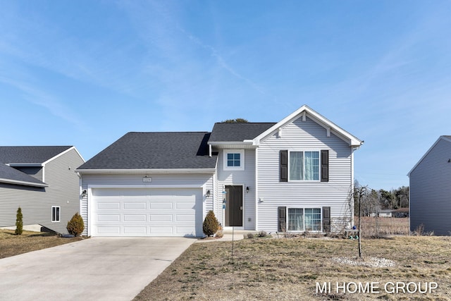 split level home featuring an attached garage, concrete driveway, and a shingled roof