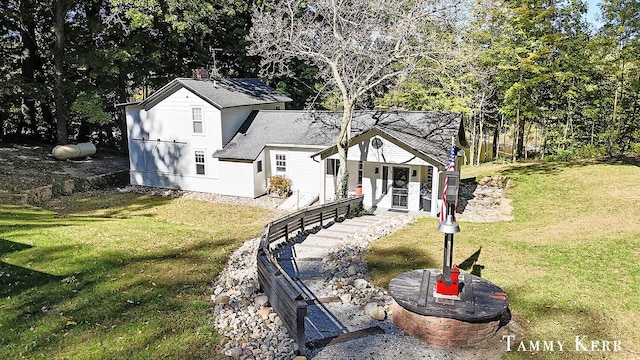 view of front facade featuring roof with shingles and a front yard