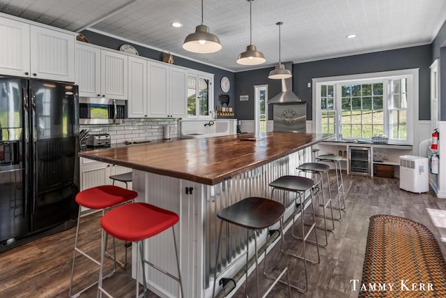 kitchen featuring stainless steel microwave, wooden counters, dark wood-type flooring, wine cooler, and black refrigerator with ice dispenser