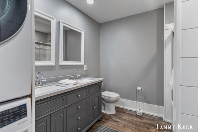 bathroom with toilet, wood finished floors, baseboards, and a sink