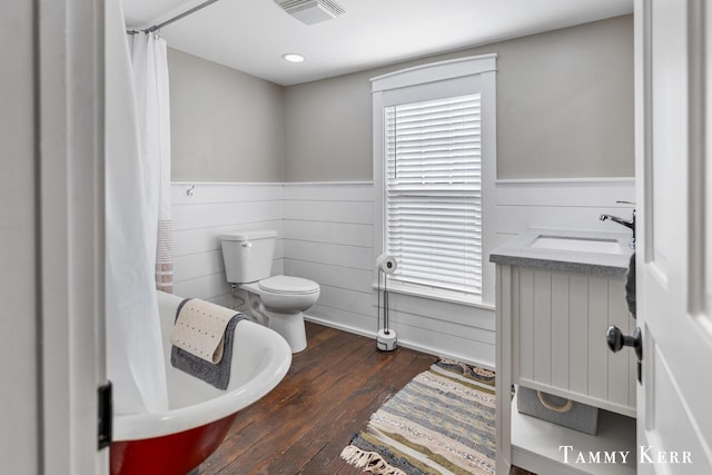 full bath with a sink, visible vents, a wainscoted wall, and hardwood / wood-style flooring