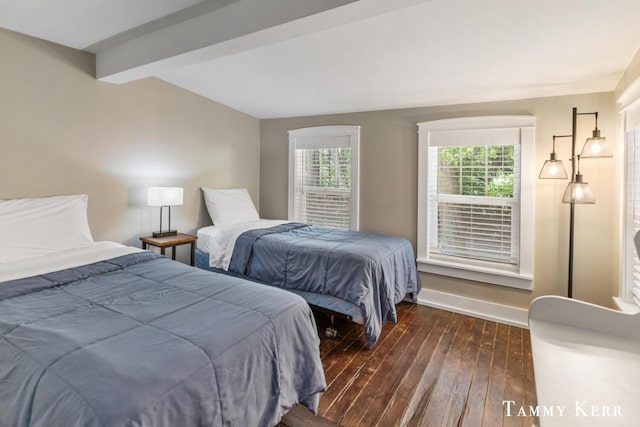 bedroom with beamed ceiling, baseboards, and dark wood-type flooring