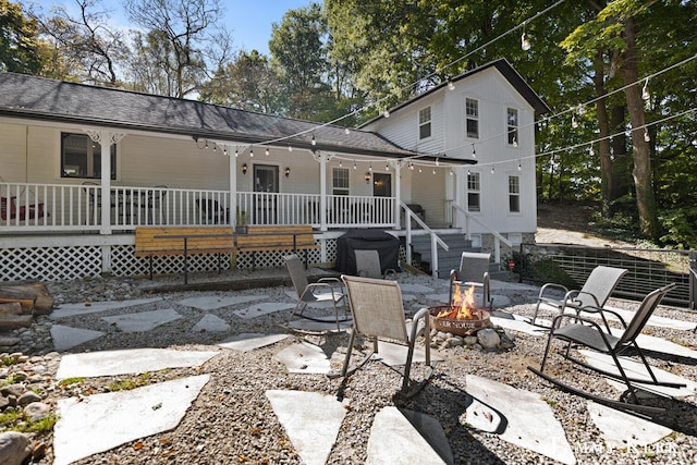 rear view of house with a patio area, covered porch, and an outdoor fire pit