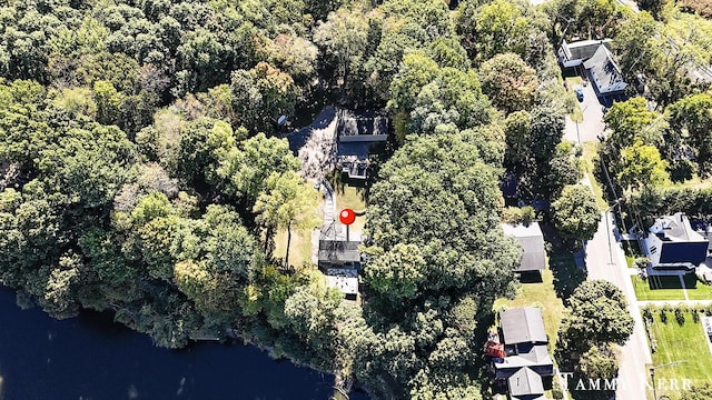 birds eye view of property with a water view and a wooded view