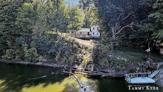 view of dock with a forest view and a water view