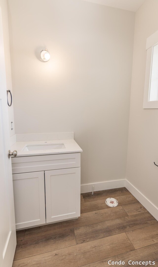 6627 Shoreside Ct SE, Grand Rapids, MI 49548 - bathroom with wood finished floors, vanity, and baseboards