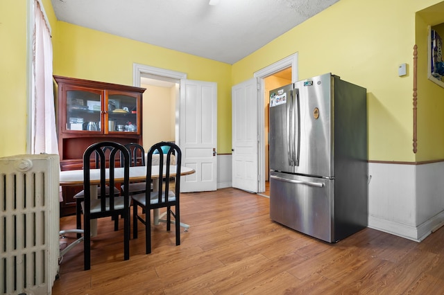 240 S Main St, Three Rivers, MI 49093 - kitchen with light wood finished floors, radiator, and freestanding refrigerator