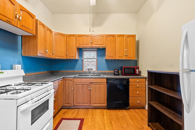 240 S Main St, Three Rivers, MI 49093 - kitchen featuring white appliances, brown cabinetry, a sink, light wood-style floors, and dark countertops