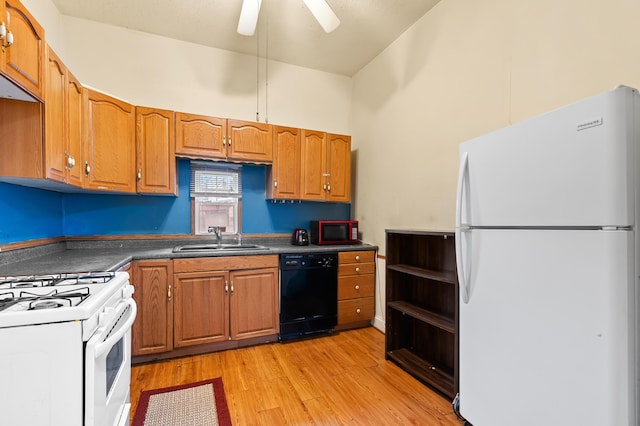 240 S Main St, Three Rivers, MI 49093 - kitchen with white appliances, brown cabinetry, a sink, dark countertops, and light wood-type flooring