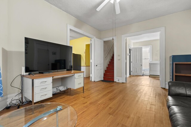 240 S Main St, Three Rivers, MI 49093 - living area featuring washer / dryer, ceiling fan, stairs, light wood-style floors, and a textured ceiling