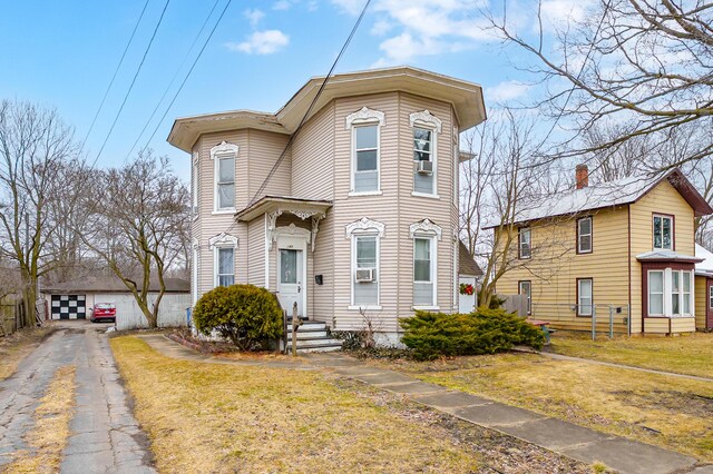 240 S Main St, Three Rivers, MI 49093 - view of front facade with a detached garage, cooling unit, and a front lawn