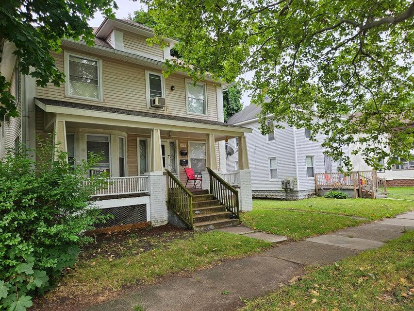 1516 Quarry Ave NW, Grand Rapids, MI 49504 - traditional style home featuring covered porch, a front yard, and cooling unit