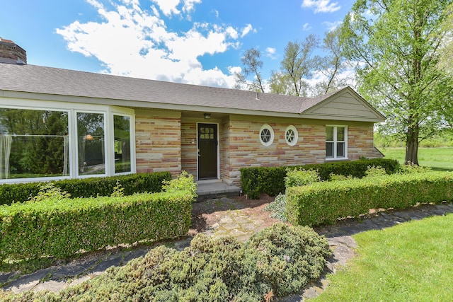 ranch-style house with stone siding and roof with shingles