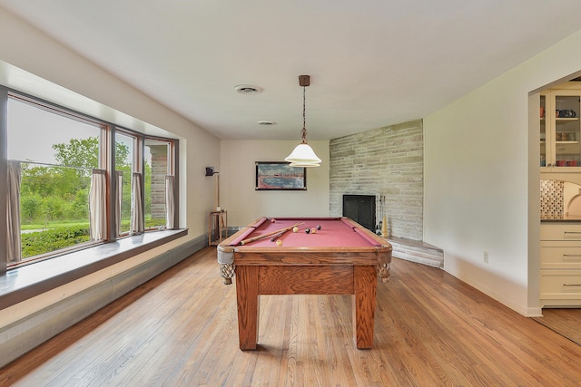 rec room with billiards, visible vents, baseboards, a stone fireplace, and light wood-type flooring