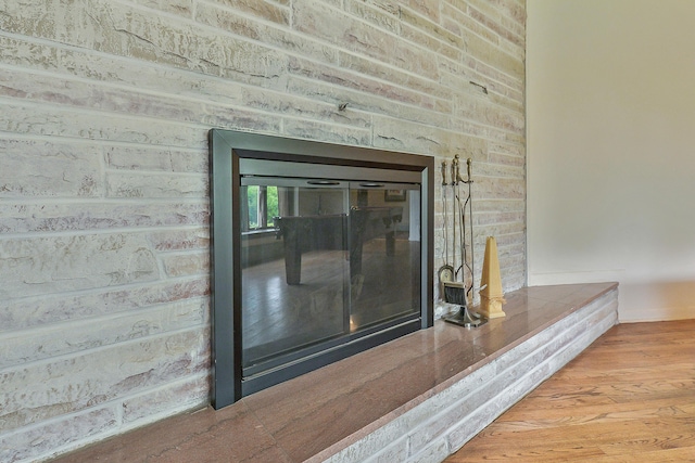 interior details with a brick fireplace and wood finished floors