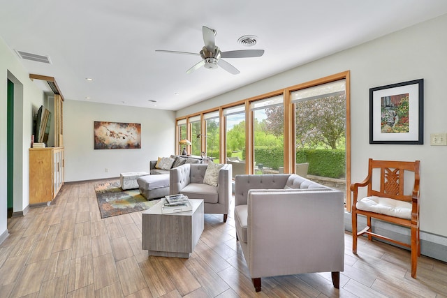 living area featuring light wood finished floors, visible vents, and ceiling fan