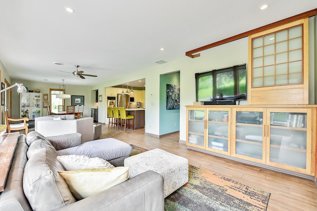 living room featuring light wood finished floors, visible vents, recessed lighting, and ceiling fan