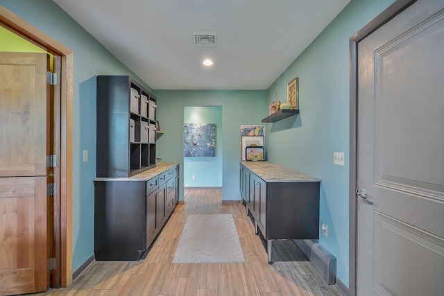 kitchen with open shelves, light countertops, visible vents, and light wood-type flooring