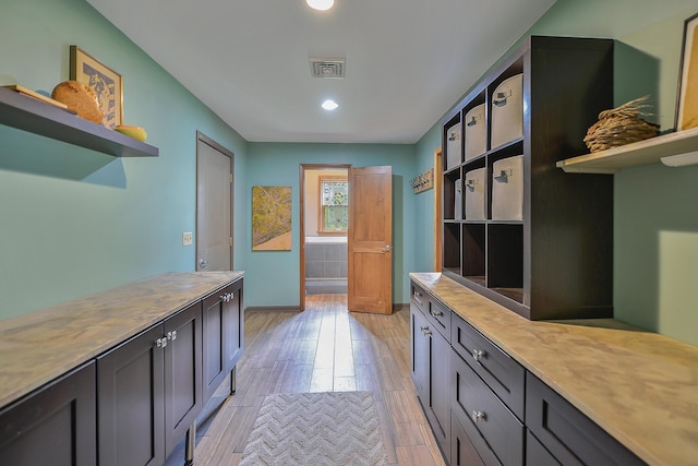 interior space featuring light wood-style floors, visible vents, and baseboards