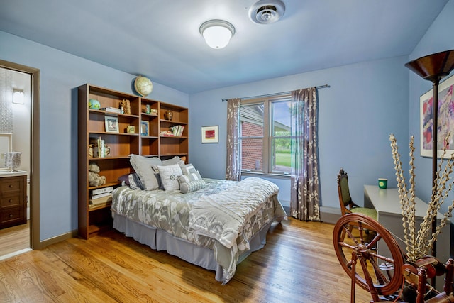 bedroom with light wood-style flooring, baseboards, and visible vents