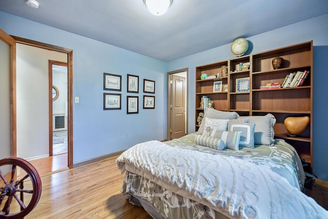 bedroom with baseboards and light wood finished floors