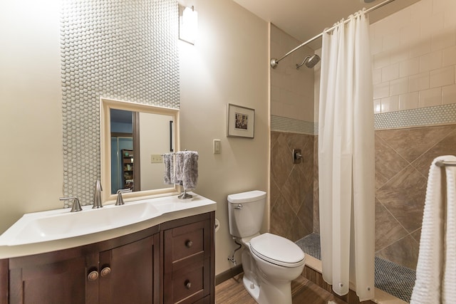 full bath with toilet, vanity, and a tile shower