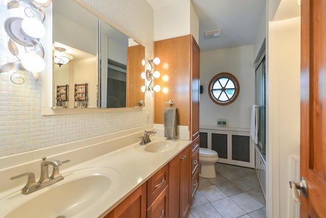 full bathroom featuring a sink, toilet, double vanity, and tile patterned floors