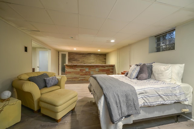 bedroom featuring a drop ceiling, recessed lighting, and wood finished floors