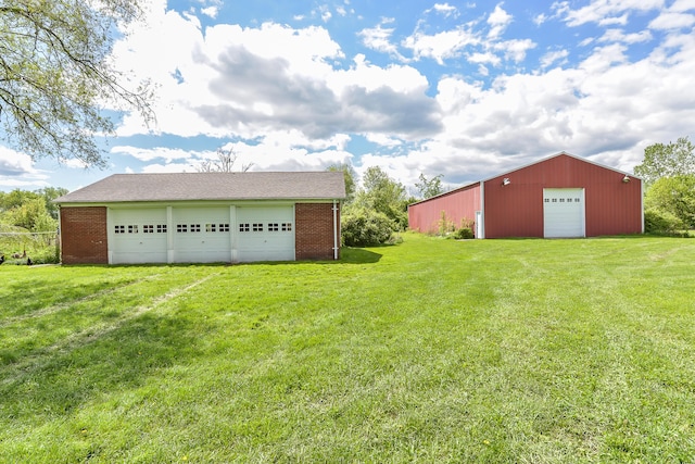 view of yard with an outbuilding, driveway, and a detached garage