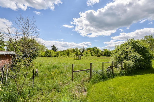 view of yard with a rural view and fence