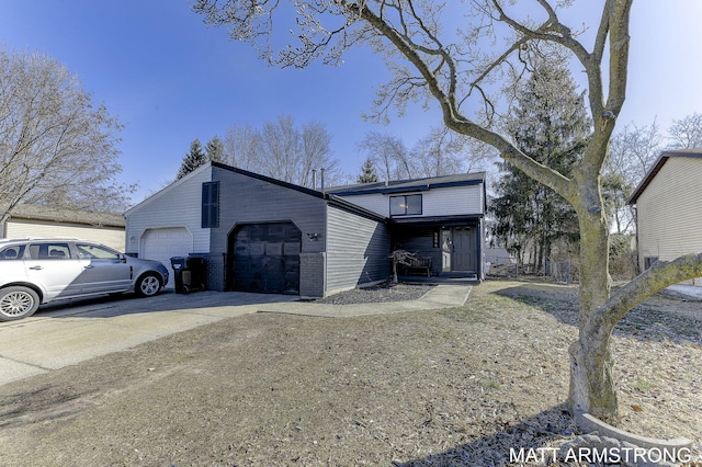 view of front of house featuring concrete driveway, brick siding, and a garage