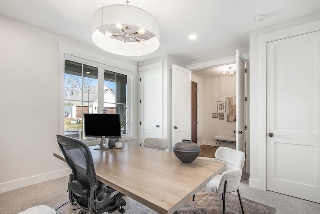 office area featuring a notable chandelier, baseboards, and carpet floors