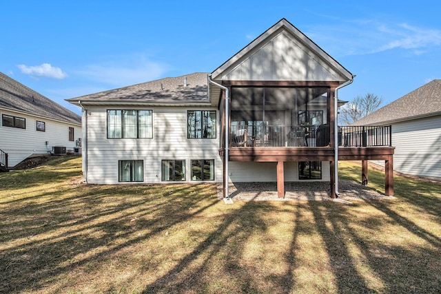 rear view of house with central air condition unit, a yard, and a sunroom