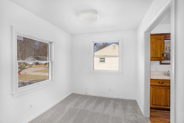 unfurnished dining area with carpet flooring and baseboards