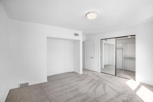 unfurnished bedroom featuring a closet, visible vents, and carpet