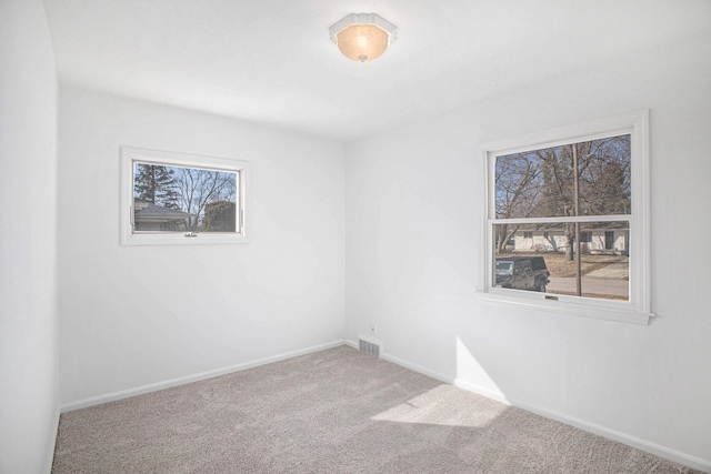 empty room with visible vents, baseboards, and carpet