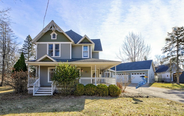victorian house with covered porch, a garage, and concrete driveway