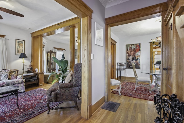 corridor with visible vents, hardwood / wood-style flooring, and baseboards