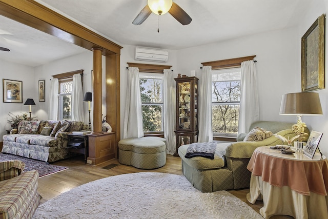 interior space featuring an AC wall unit, a ceiling fan, and a healthy amount of sunlight