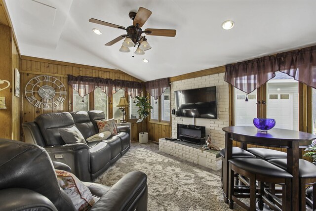 living room featuring wood walls, ceiling fan, carpet floors, and vaulted ceiling